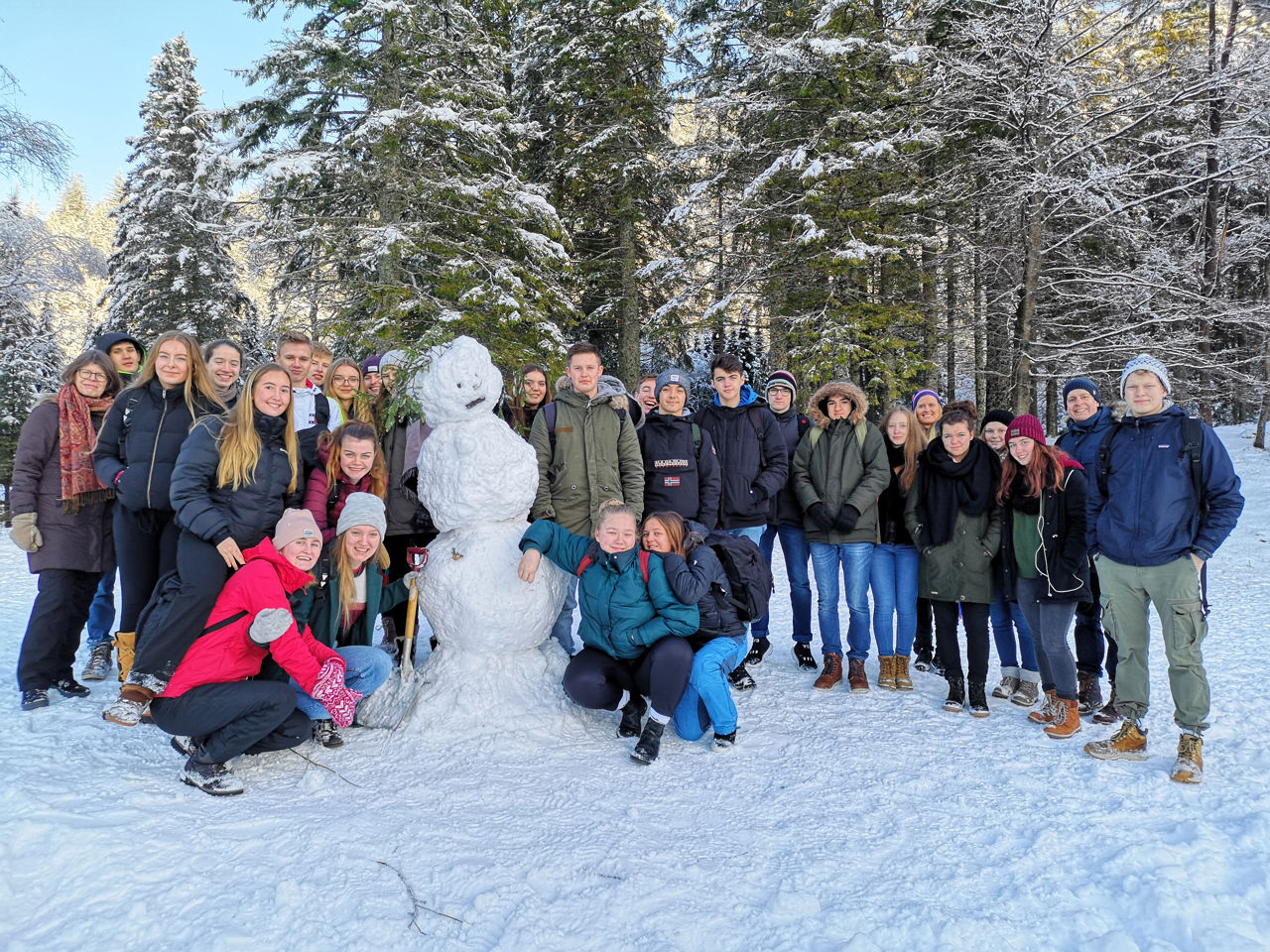 Bilde av elever fra Spania som står med en snømann i Norge