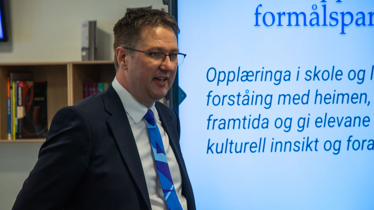 Rektor held presentasjon om skulen og opplæring.